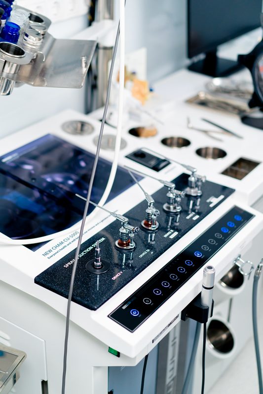 Equipo médico con panel de control y accesorios en una sala clínica