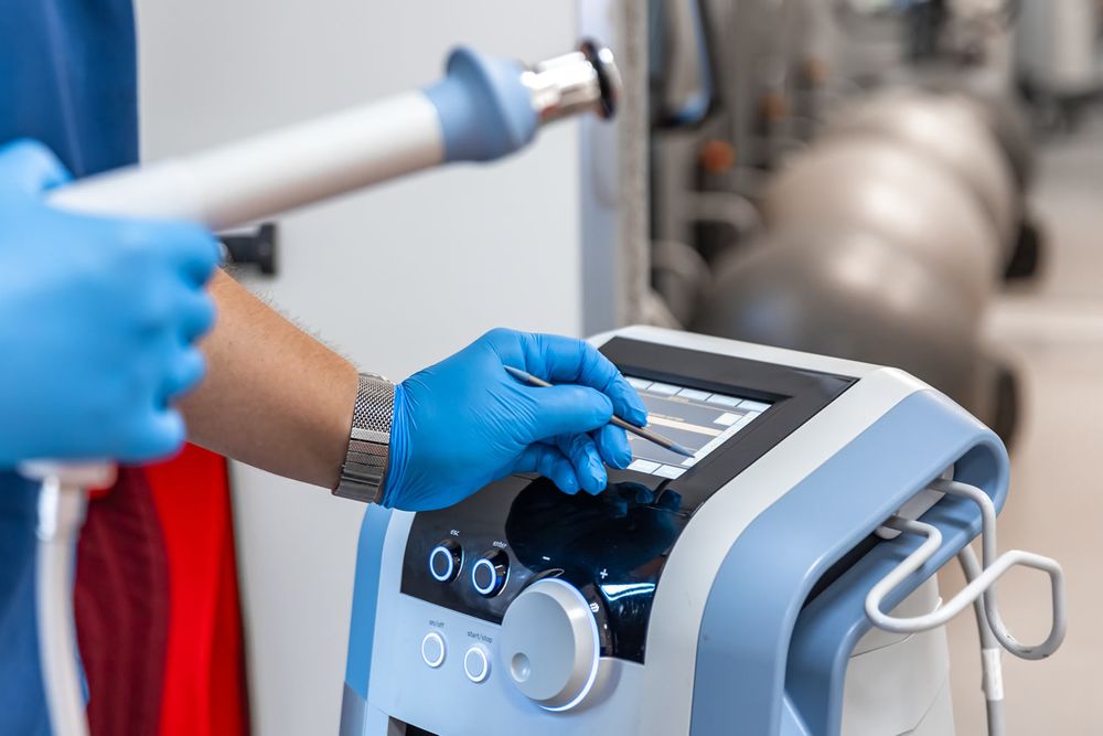 Manos con guantes ajustan los controles de un equipo biomédico